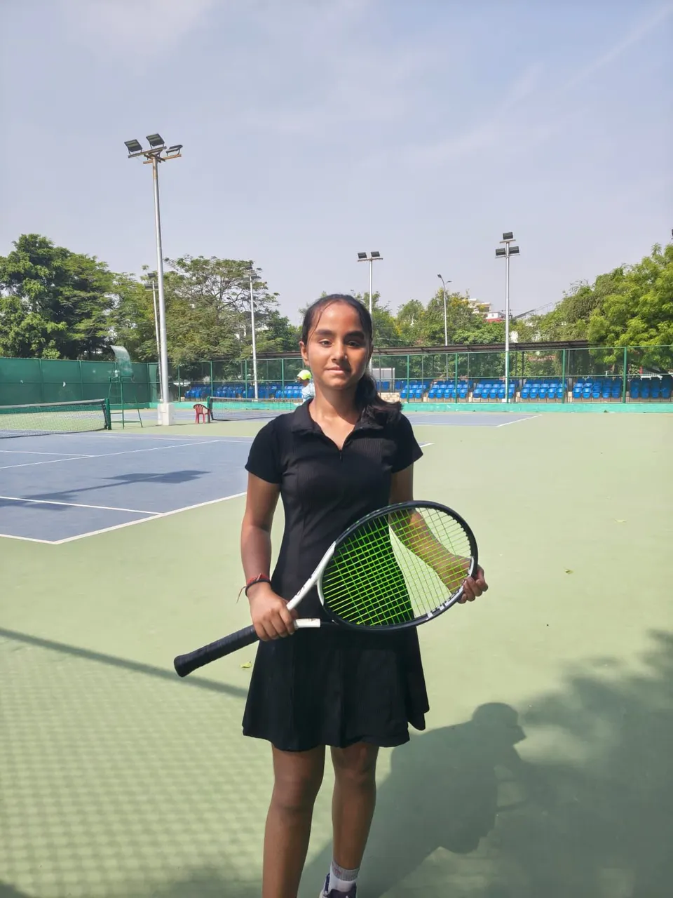 Siya, a PLAY n FIT player, holding her racquet on a hard court